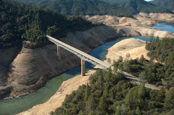 Image of bridge over llow level water indicating drought.